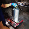 Teamaker packing a cylinder with loose tea in Yunnan, China.
